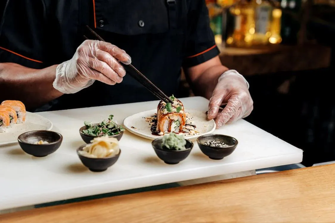 Sushi chef preparing specialty roll with chopsticks at Kumo Sushi & Hibachi, a Japanese Restaurant in Alachua